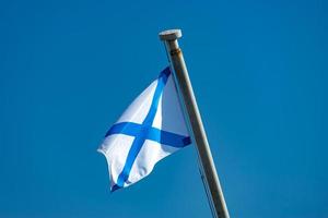 Naval flag on blue sky background. photo