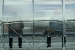 People at the bus stop are waiting for public transport. photo