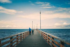 Seascape overlooking the long pier of the resort town with walking people. photo