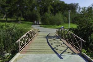 Elegante puente de madera sobre un fondo de parque público en un día soleado foto