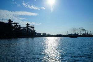 Silhouette of industrial structures in the background of the sea photo