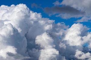 White fluffy clouds on the tops of mountains photo