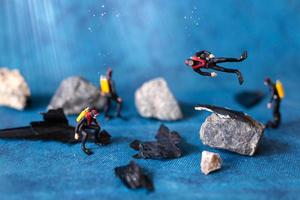 Miniature people, scuba divers clean up plastic rubbish pollution discarded in the ocean, underwater pollution concept photo