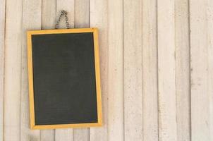 Blank copyspace black board on wooden wall. photo