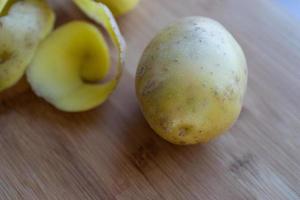 Raw potatoes with peel on a cutting Board photo