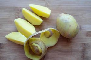 Raw potatoes with peel on a cutting Board photo