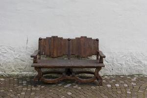 wooden bench handmade on the background of white walls and pavers photo