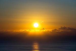brillante puesta de sol sobre el mar desde foto