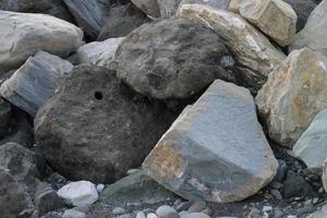 enormes piedras en el mar para proteger la orilla del desenfoque foto