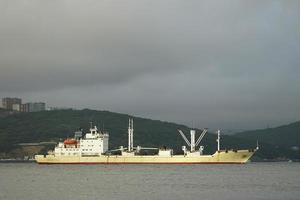 Fishing boat on the background of the coastline . photo