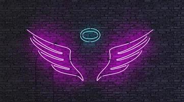 Neon lamp with angel shape on brick wall photo
