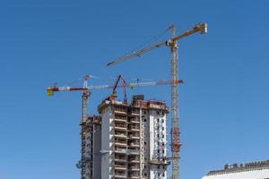 Industrial landscape with silhouettes of cranes on a blue sky photo