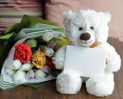 Teddy bear and blank post card with bouquet photo
