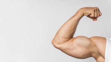 Vista frontal del hombre en forma mostrando bíceps con espacio de copia foto