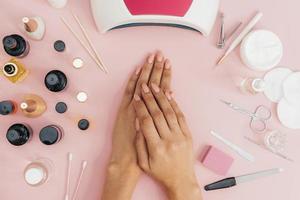 Cuidado de la higiene de las uñas esmalte de uñas sobre fondo de color rosa foto