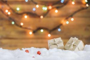 Present boxes on decorative snow near fairy lights