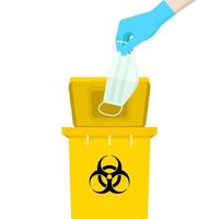 Hand holding a mask is above the yellow bin, with the symbol of infectious waste. How to discard the surgical mask correctly. vector