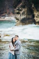 joven pareja enamorada en un río de montaña foto