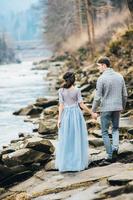 Young couple in love on a mountain river photo