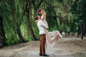 A guy and a girl are walking along the banks of a wild river overgrown photo