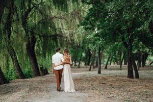 A guy and a girl are walking along the banks of a wild river overgrown photo