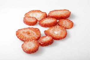 Sliced strawberries on white background photo