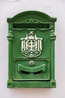 Green metal antique mailbox on a white house wall in old NIcosia, Cyprus photo