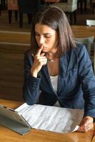 Concentrated and absorbed brunette businesswoman at work sitting at her desk photo