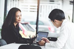 Two business executives discussing charts on tablet photo