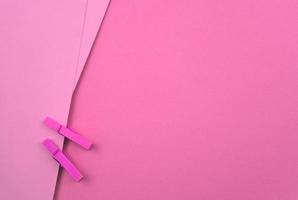 Pink paper background with clothespins photo