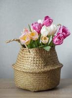 canasta con tulipanes de colores de primavera foto