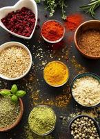 Colorful and aromatic herbs and spices on a dark background photo