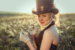 young blonde girl in a brown vintage dress and top hat photo