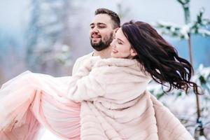 young couple on a walk in the snowy mountains photo