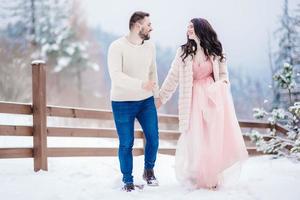 young couple on a walk in the snowy mountains photo