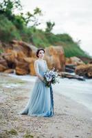 bride with a bouquet of flowers on the beach photo