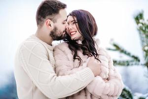 young couple on a walk in the snowy mountains photo