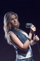 young blonde girl in jeans clothes on a dark background photo