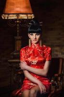 girl in a red Japanese silk dress qipao in a dark room photo