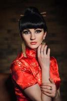 girl in a red Japanese silk dress qipao in a dark room photo