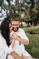 Pareja joven enamorada de un chico con barba y una chica de cabello oscuro con ropa clara foto