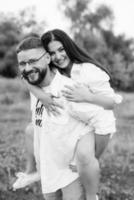 young couple in love a guy with a beard and a girl with dark hair in light clothes photo