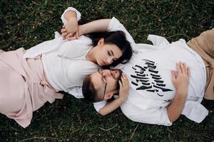 young couple in love a guy with a beard and a girl with dark hair in light clothes photo