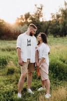 young couple in love a guy with a beard and a girl with dark hair in light clothes photo