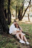 young couple in love a guy with a beard and a girl with dark hair in light clothes photo