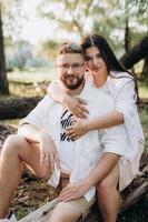 young couple in love a guy with a beard and a girl with dark hair in light clothes photo