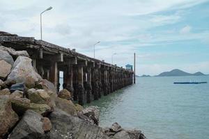 Carretera de hormigón hacia el mar con paisaje e isla de fondo. paisaje marino y la estructura del puerto en el mar. foto