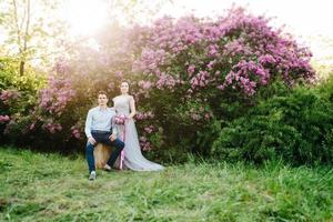 a guy and a girl walk in the spring garden of lilacs photo