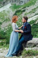 young couple on a walk near the lake surrounded by the mountains photo