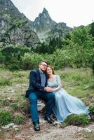 young couple on a walk near the lake surrounded by the mountains photo